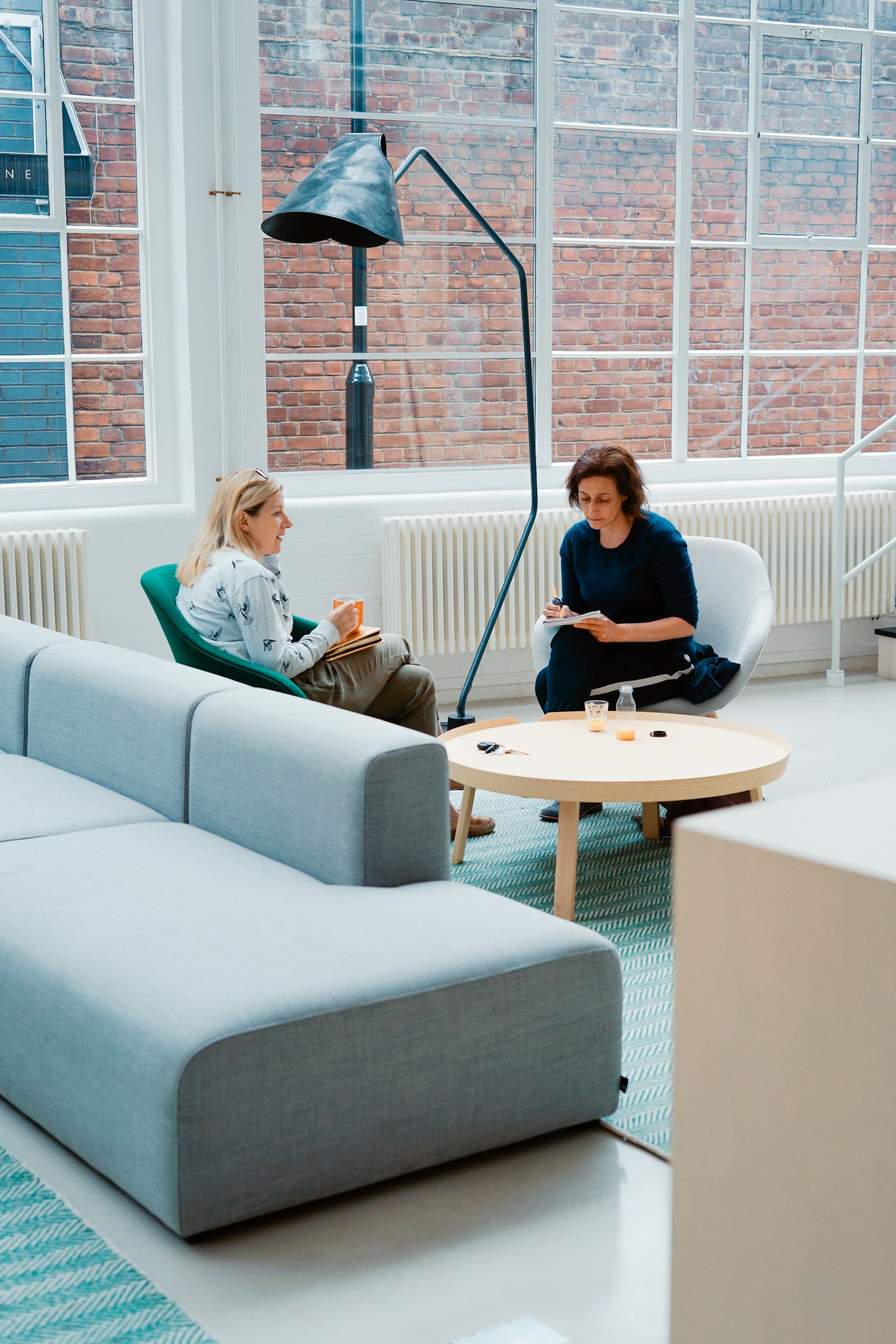 Dos profesionales conversan en un espacio de trabajo luminoso